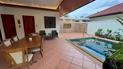 a dining room with a table and a swimming pool at Lai Thai Villa 5 in Rawai Beach