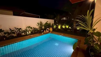 a swimming pool in a backyard at night at Lai Thai Villa 5 in Rawai Beach