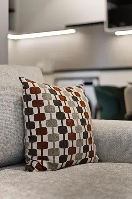 a brown and white pillow sitting on a couch at Bangtao The Title Legendary by Phuket Sabay Rent I302 in Bang Tao Beach