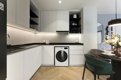 a white kitchen with a washer and a table at Bangtao The Title Legendary by Phuket Sabay Rent I302 in Bang Tao Beach