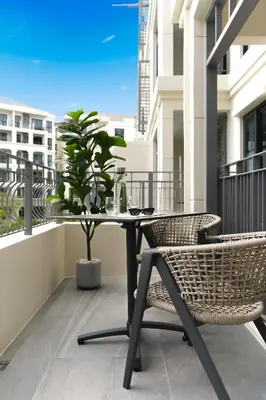 a table and chairs on a balcony with a potted plant at Bangtao The Title Legendary by Phuket Sabay Rent I302 in Bang Tao Beach