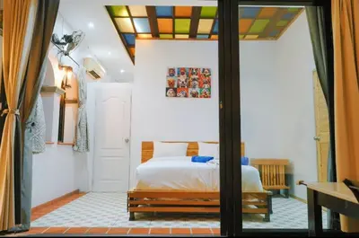 a bedroom with a bed and a glass door at Beautiful 4 bedroom ocean view white house, steps from the beach Rawai Beach in Nai Harn Beach