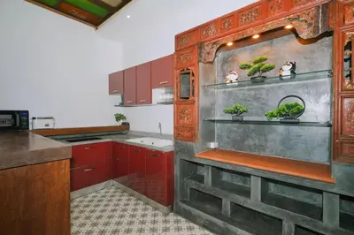 a kitchen with red cabinets and potted plants on shelves at Beautiful 4 bedroom ocean view white house, steps from the beach Rawai Beach in Nai Harn Beach