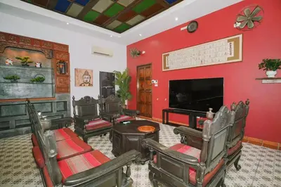 a living room with red walls and a flat screen tv at Beautiful 4 bedroom ocean view white house, steps from the beach Rawai Beach in Nai Harn Beach