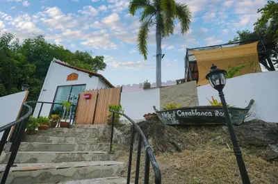 a sign in front of a building with a palm tree at Beautiful 4 bedroom ocean view white house, steps from the beach Rawai Beach in Nai Harn Beach