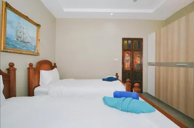 a bedroom with two beds with blue pillows at Beautiful 4 bedroom ocean view white house, steps from the beach Rawai Beach in Nai Harn Beach