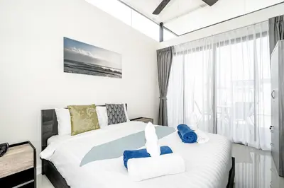 a bedroom with a white bed with blue towels on it at Laguna Cozy 3 bedroom town house 800m to beach in Laguna Phuket