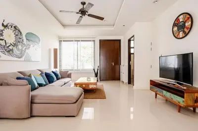 a living room with a couch and a flat screen tv at Laguna Cozy 3 bedroom town house 800m to beach in Laguna Phuket