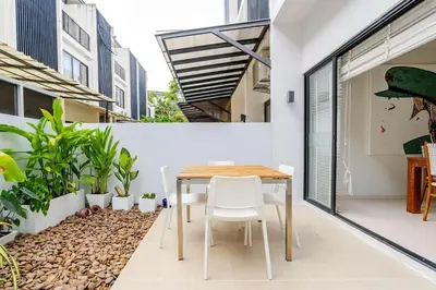 a dining room with a table and some plants at Laguna Cozy 3 bedroom town house 800m to beach in Laguna Phuket