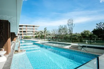 a large swimming pool with a building in the background at New Boutique Studio, Near the Sea in Layan Beach