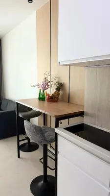 a kitchen with a wooden table and a counter top at The Regent new apartment in Ban Thalat Choeng Thale