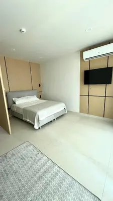 a bedroom with a bed and a television in it at The Regent new apartment in Ban Thalat Choeng Thale