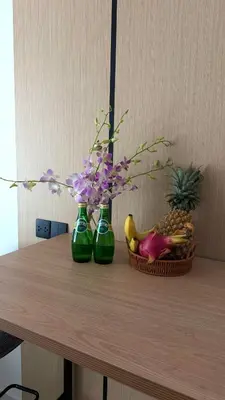 three green vases with flowers and a basket of fruit at The Regent new apartment in Ban Thalat Choeng Thale
