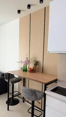 a kitchen with a wooden table and two chairs at The Regent new apartment in Ban Thalat Choeng Thale