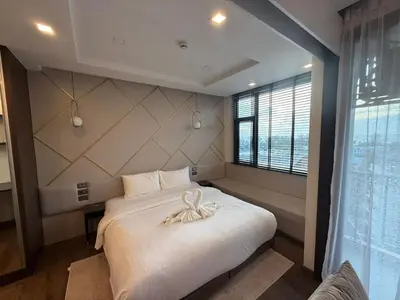 a bedroom with a large white bed and a window at The Proud Karon Phuket - New 1BR Apartment 6floor in Karon Beach