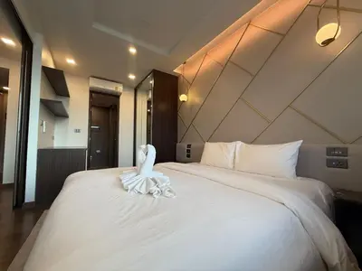 a bed with a white bird sitting on top of it at The Proud Karon Phuket - New 1BR Apartment 6floor in Karon Beach
