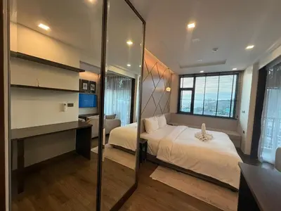 a bedroom with a bed and a mirror at The Proud Karon Phuket - New 1BR Apartment 6floor in Karon Beach