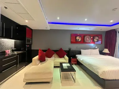 a bedroom with a bed and a couch and a table at Patong Condo Tub, Roof Pool & 2-min to Beach in Patong Beach