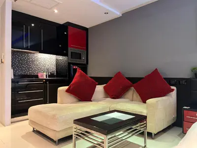 a living room with a couch and red pillows at Patong Condo Tub, Roof Pool & 2-min to Beach in Patong Beach