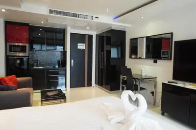 a bedroom with a bed with two white swans at Patong Condo Tub, Roof Pool & 2-min to Beach in Patong Beach