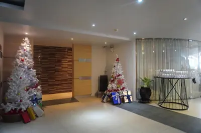 two christmas trees in a lobby with presents at Patong Condo Tub, Roof Pool & 2-min to Beach in Patong Beach