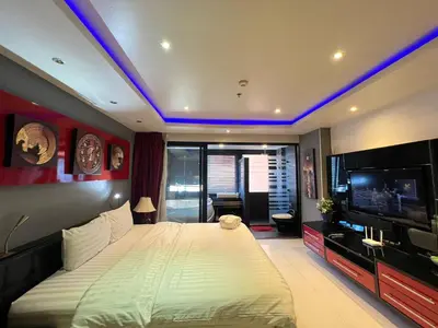 a bedroom with a large bed and a tv at Patong Condo Tub, Roof Pool & 2-min to Beach in Patong Beach