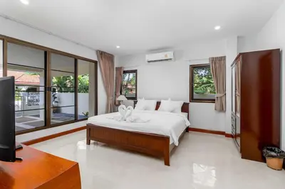 a bedroom with a bed and a flat screen tv at V278 Quiet Poolside 3BR Villa for Relaxed Stays in Ban Bang Chak