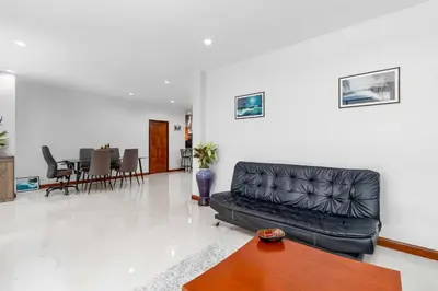 a living room with a black leather couch and a table at V278 Quiet Poolside 3BR Villa for Relaxed Stays in Ban Bang Chak