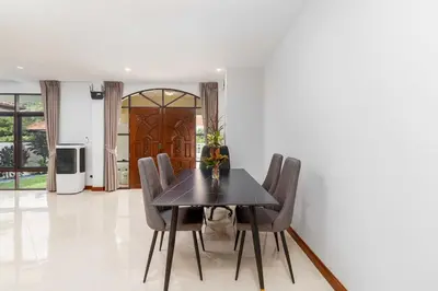 a dining room with a black table and chairs at V278 Quiet Poolside 3BR Villa for Relaxed Stays in Ban Bang Chak