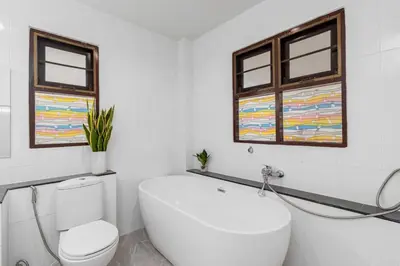 a bathroom with a white toilet and two windows at V278 Quiet Poolside 3BR Villa for Relaxed Stays in Ban Bang Chak