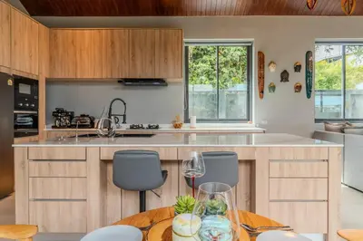 a kitchen with wooden cabinets and a table with chairs at V280 If You Need Luxury This Is The Place Fully Smart in Ban Saiyuan (1)