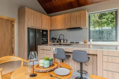 a kitchen with wooden cabinets and a wooden table and chairs at V280 If You Need Luxury This Is The Place Fully Smart in Ban Saiyuan (1)