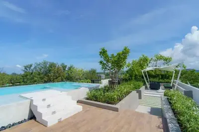 a large swimming pool with stairs and aitating at Apartments in the center of Laguna in Laguna Phuket