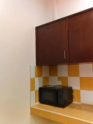 a microwave sitting on a shelf in a kitchen at Tangerine Villa Patong in Patong Beach