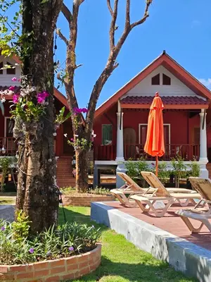 an orange umbrella and chairs in front of a house at Tangerine Villa Patong in Patong Beach