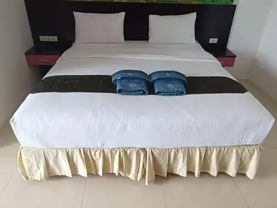 a white bed with two blue pillows on it at \u82ad\u4e1c\u4e00\u5367\u5927\u5e8a\u623f\u72ec\u7acb\u6dcb\u6d74\u9633\u53f0 in Patong Beach