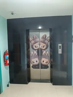a row of elevators with faces painted on the wall at \u82ad\u4e1c\u4e00\u5367\u5927\u5e8a\u623f\u72ec\u7acb\u6dcb\u6d74\u9633\u53f0 in Patong Beach