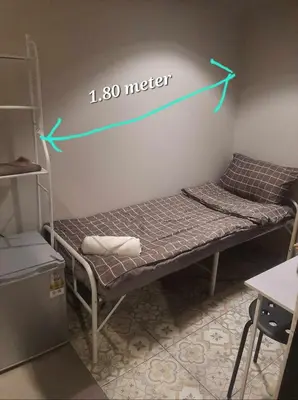 a room with a bed with a measuring needle on the wall at FanRoomGroundFlNonehotshower in Ban Ket Ho