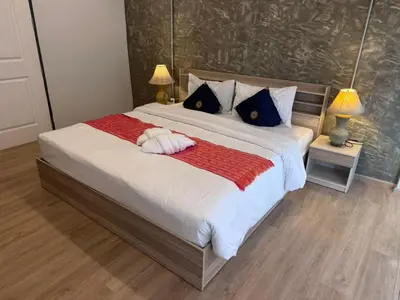a bedroom with a large bed with a dog laying on it at Global Hills View in Patong Beach