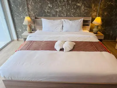 a bedroom with a large bed with towels on it at Global Hills View in Patong Beach