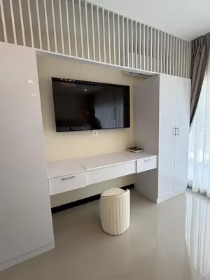 a white living room with a tv on a wall at Luxury villa with sea view, pool and maid in Patong Beach
