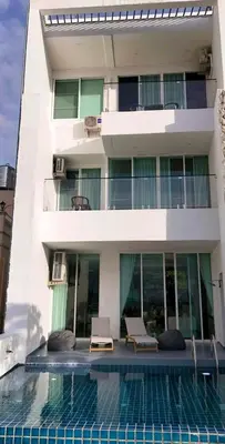 a building with a swimming pool in front of a building at Luxury villa with sea view, pool and maid in Patong Beach