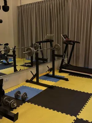 a gym with several tread machines and a mirror at Luxury villa with sea view, pool and maid in Patong Beach