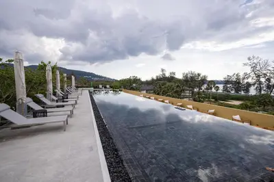 a swimming pool with lounge chairs and umbrellas at Premium 1BR Laguna, 200m to the Beach in Bang Tao in Bang Tao Beach