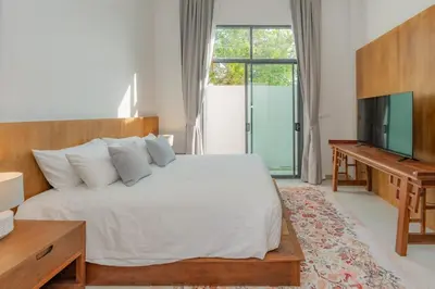 a bedroom with a white bed and a television at URMI VILLA, Brand New Luxury 6BR Pool, Bang Tao in Koh Lone