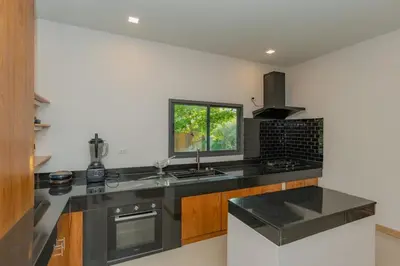 a kitchen with black counter tops and a window at URMI VILLA, Brand New Luxury 6BR Pool, Bang Tao in Koh Lone