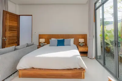 a bedroom with a large bed and a couch at URMI VILLA, Brand New Luxury 6BR Pool, Bang Tao in Koh Lone