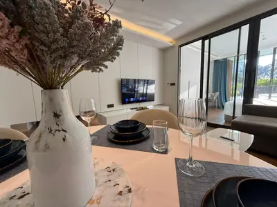 a vase with flowers on a table in a living room at Sunshine BEACH FRONT access to the pool in Layan Beach