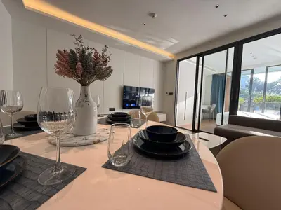 a dining room table with glasses and a vase on it at Sunshine BEACH FRONT access to the pool in Layan Beach