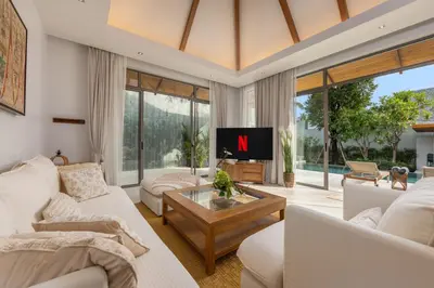 a living room with white furniture and a tv at Private 3BR Pool Villa Mana at Anchan Tropicana in Ban Phru Champa